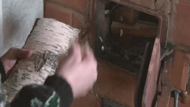 Les vieilles mains de femmes ont mis une bûche dans la cheminée en feu . — Video