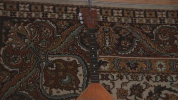 古いカーペットの背景に優れたBalalaika — ストック動画