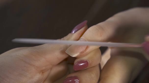ネイルポリッシュを女性の爪に適用する美容師のクローズアップショット フォーカスを追え — ストック動画