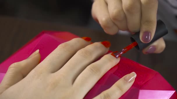 Specialisten Täcker Nageln Klienten Med Rött Lack Och Korrigerar Misstag — Stockvideo