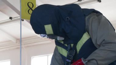 04.20.2019 Minsk Belaus. Tehlikeli madde ekipmanlı bir adam terk edilmiş fabrikada laboratuvar malzemelerini alıyor. Kapalı.