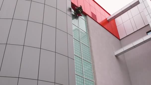 03.12.2019 Minsk Belaus.Fireman descending hanging on a glassy building facade on a rope — Stock Video