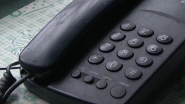 Yalnız yaşlı bir adam eski siyah bir telefondan numara çeviriyor..