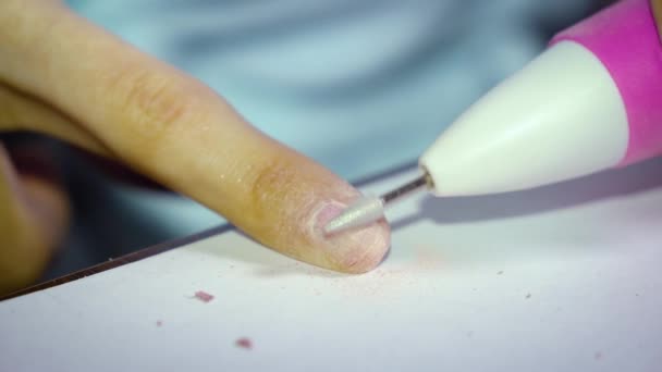 爪が醜い女の子はマニキュアのために準備するために特別な機械で爪から爪の磨きを削除します — ストック動画