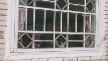Opsa, Beyaz Rusya, Şubat 2019. Yaşlı adam eski masada oturmuş sıcak bir içki içiyor ve pencereden dışarı bakıyor.