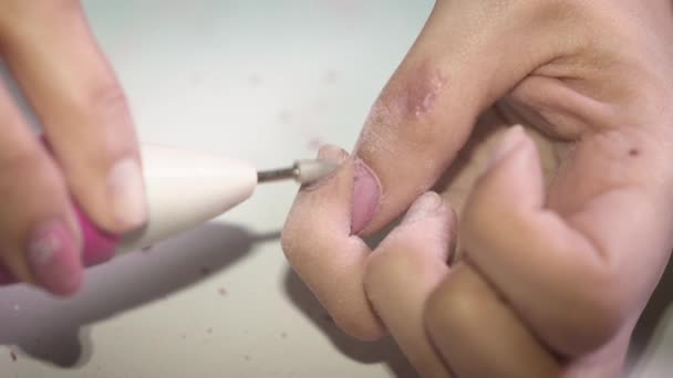 Doma dívka odstraňuje lak na nehty speciálním přístrojem, který se připravuje na manikúru. Detailní — Stock video