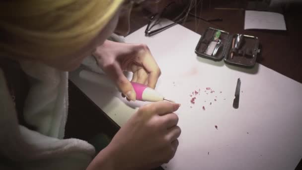 Дівчина вдома видаляє лак для нігтів за допомогою спеціальної машини для приготування манікюру . — стокове відео