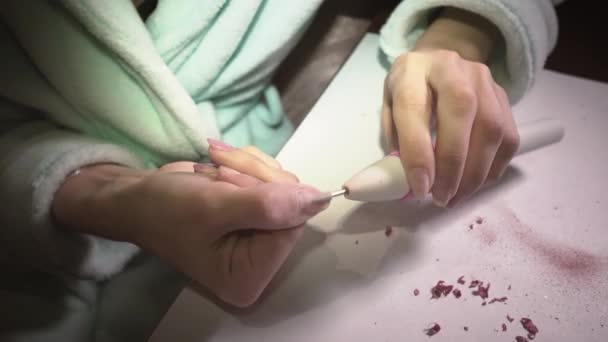 Chica en casa elimina el esmalte de uñas con una máquina especial para prepararse para una manicura. Primer plano — Vídeos de Stock