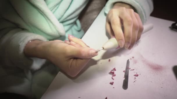Dziewczyna w domu usuwa lakier do paznokci ze specjalną maszyną do przygotowania do manicure. Zbliżenie — Wideo stockowe