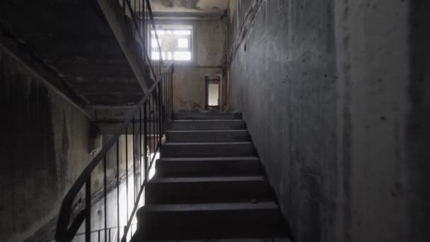 Escalade d'escaliers agités dans l'obscurité. Monter seul des escaliers sombres et dangereux dans une cage d'escalier crémeuse.