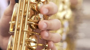 Akşam yemeği ceketli saksafoncu, altın saksafonda çalıyor. Canlı performans. Caz müziği.