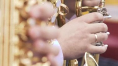 Akşam yemeği ceketli saksafoncu, altın saksafonda çalıyor. Canlı performans. Caz müziği. Odağı izle..
