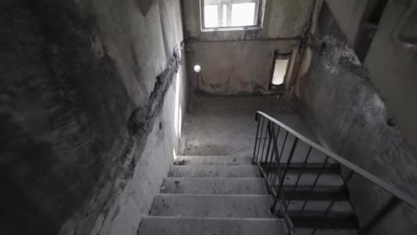 Escalade d'escaliers agités dans l'obscurité. Monter seul des escaliers sombres et dangereux dans une cage d'escalier crémeuse. mouvement lent. Explosion