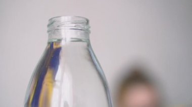 Genç kadın evde su şişesi içiyor. 4k