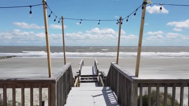 Lange houten pier die leidt van naar de prachtige oceaan. Witte wolken en blauw water. Slow Motion wandelen naar het einde van de Pier — Stockvideo