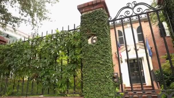 晴れた日に古い家の背景に石の壁に金属製の門 — ストック動画