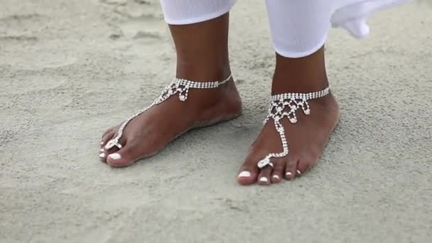 Pies y dedos femeninos sobre arena en verano. Hermosos pies de mujer en la arena.Las piernas de una joven mujer negra están decoradas para la boda. mujer afroamericana . — Vídeos de Stock