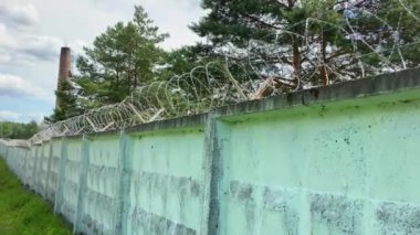 Dikenli Tel ve Çelik Çelik Duvarla çevrili teller ormandaki mavi gökyüzüne, Hapishane Kavramı, Kurtuluş, Mülteci. Güvenlik sistemleri kısıtlı. İnsan özgürlüğünün kısıtlanması 4K