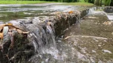 Su merdivenlerden aşağı akıyor ve şehri sel basıyor. Yağmur damlaları düşüyor, sokakları sel basıyor. Yağmur mevsiminde yollar taşar. Şiddetli sağanak yağış ve sağanak yağmurun ardından ani seller