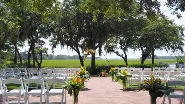 Arco de casamento, acessórios e decorações. Cerimônia de casamento em um belo dia ensolarado. Bela configuração de casamento, Bouquets of Natural Fresh Flowers. Fileiras de cadeiras brancas. Felizes amantes 4k — Vídeo de Stock