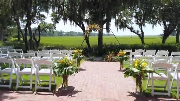 結婚式のアーチ、アクセサリーや装飾。美しい晴れた日に結婚式。美しい結婚式のセットアップ、自然の新鮮な花の花束。白い椅子の列。幸せな恋人4k — ストック動画