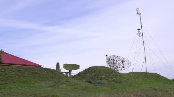 Militärisches Kampfradar in Armeefarbe mit wolkenlosem Himmel. Im grünen Wald getarntes Radar sendet Funkwellen aus, um Flugzeuge oder Schiffe zu erkennen. Dreht den Luftraum mit einem schmalen Strahl 4k fegen — Stockvideo