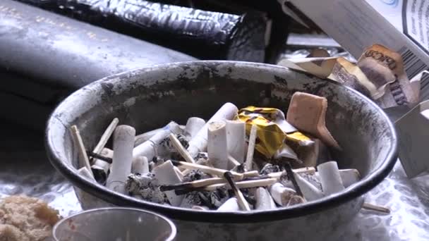 用用过的香烟把烧好的木制火柴放在肮脏的烟灰缸里 火灾的原因 不道德的生活原则 有害的习惯 吸烟者和饮酒者 家庭中的问题 — 图库视频影像