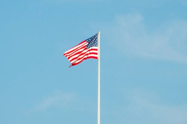 Mavi gökyüzü üzerinde dalgalanan ABD bayrağını.