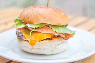 Çizburger doğranmış Dana pirzola peynir, pastırma, roka ve soslu beyaz tabakta ile gelen.