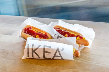 Gdansk, Polonya - 19 Eylül 2018: Üç IKEA ahşap masa ketçap ve hardal ile hot-dogs.