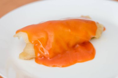 Golabki domates soslu. Beyaz tabakta et ve pilav ile Lehçe lahana rulo.