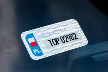 Polish sticker with register number of car inside of windshield. clipart