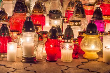 Gece mezarlıkta mezar yanan mumlar.