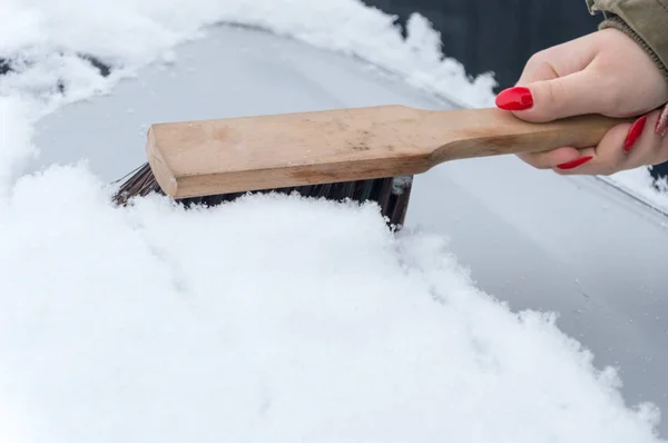 Mulher mão limpeza neve do carro com escova . — Fotografia de Stock
