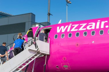 Gdansk, Poland - May 28, 2018: People embarking to Wizz Air plane at the airport. clipart