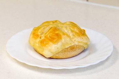 Üstünde ızgara peynir ile Kaiser rulo.