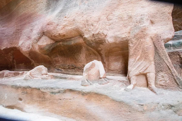 Antieke mens en kameel sculpturen in zandsteen muur van Siq gesneden — Stockfoto