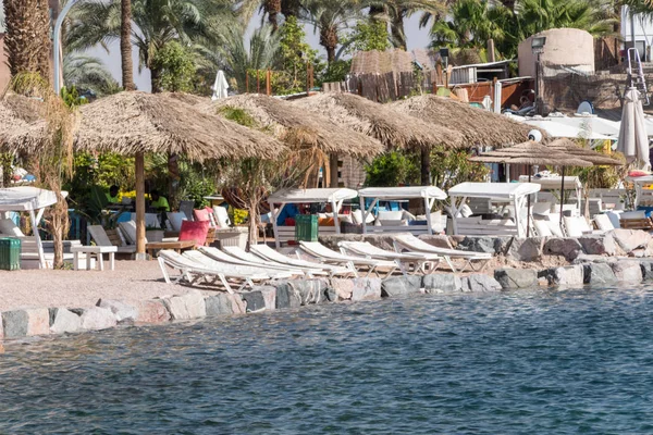 Couches and umbrellas on the beach of Eilat. — Stock Photo, Image