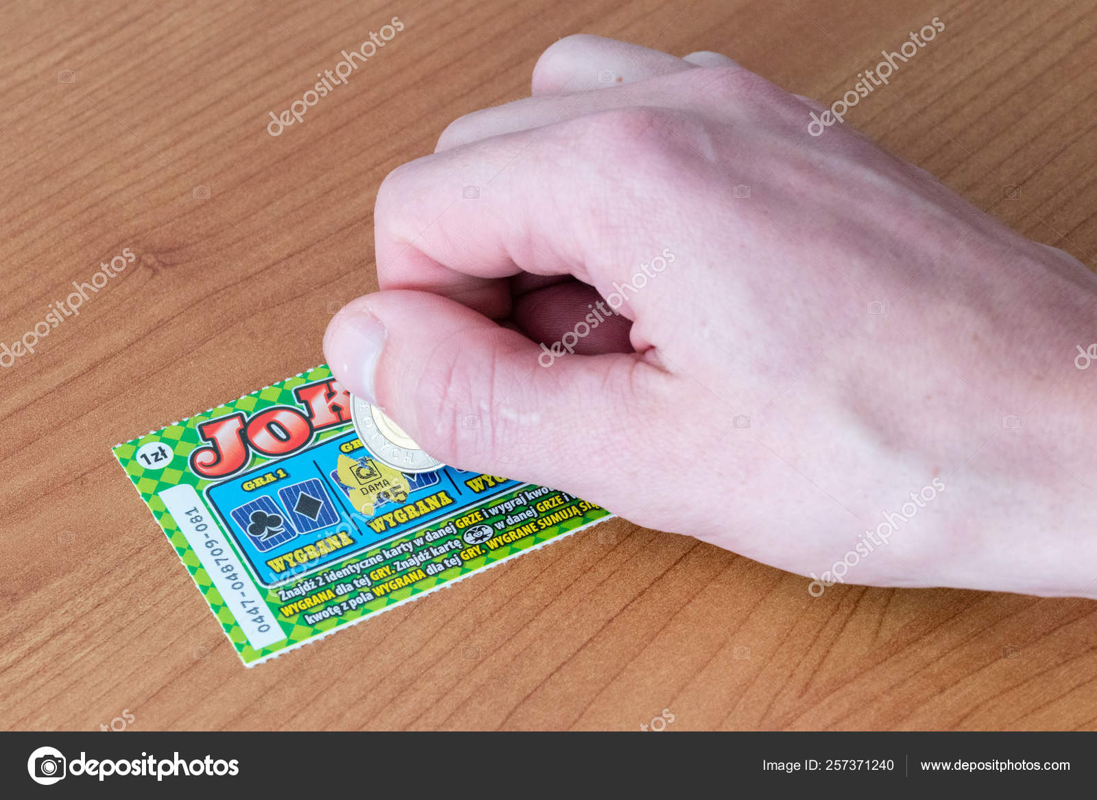Scratching a scratch off Lotto lottery ticket. Stock Editorial