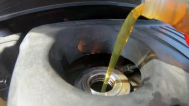 Otomobil motoruna motor yağı dökme.