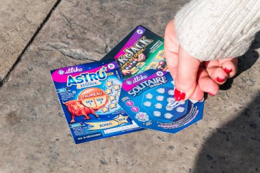 Bir Fransız piyango kazıkazan kartını çiviyle tırmalama kadın eli.