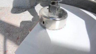 Beyaz seramik karo yuvarlak bir delik kesin.