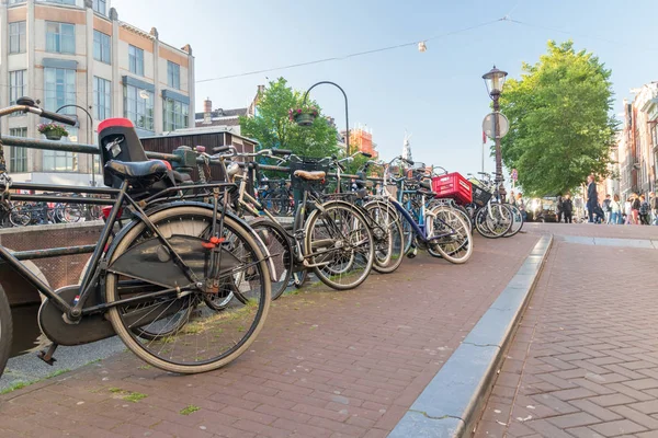 Jízdní kola zaparkovaná podél průplavu v historickém obvodu Amsterdamu. — Stock fotografie