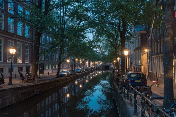 Nattvy över Canal med lampor i Amsterdam. — Stockfoto