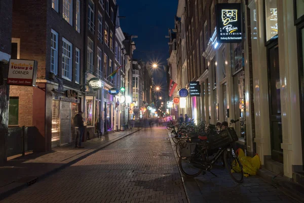 Warmoesstraat calle en el centro histórico de la ciudad en la noche . — Foto de Stock