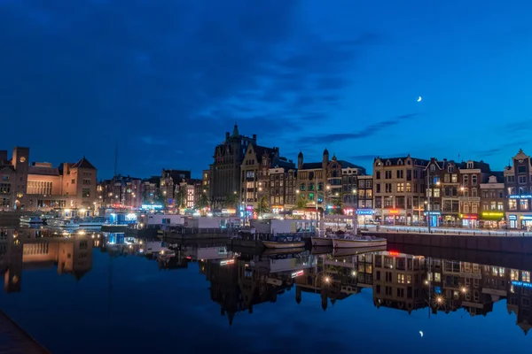 Nádherné staré město v Amsterdamu nad kanálem Damrak za soumraku. — Stock fotografie