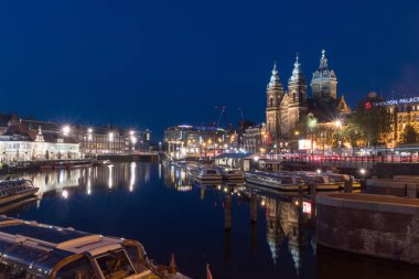 Alacakaranlıkta Aziz Nikolaos Bazilikası ile Amsterdam kanalı.