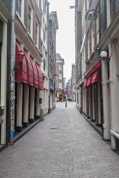 Calle estrecha en De Wallen con puertas de cristal a habitaciones alquiladas por prostitutas . — Foto de Stock