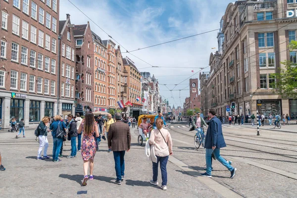 Mucha gente en la calle Damrak en Amsterdam . — Foto de Stock