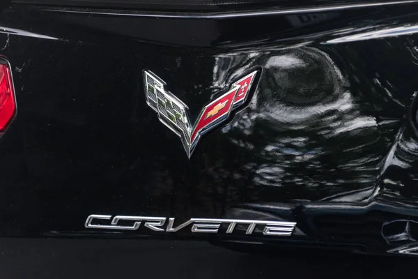 Logo de Chevrolet Corvette y cartel de Corvette en coche negro . — Foto de Stock